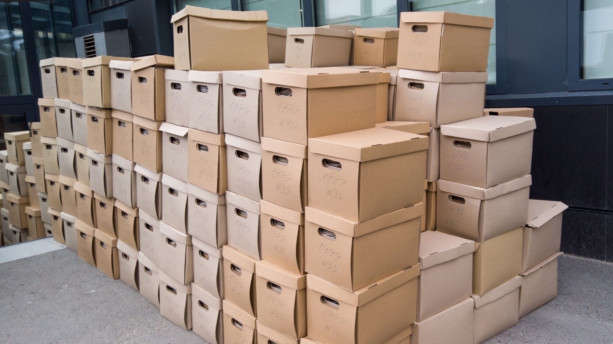 Many document archive boxes are neatly stacked on the floor.